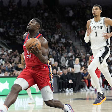 Dec 17, 2023; San Antonio, Texas, USA; New Orleans Pelicans Zion Williamson (1) drives to the basket past San Antonio Spurs guard Devin Vassell (24) and forward Victor Wembanyama (1) during the first half at Frost Bank Center. Mandatory Credit: Scott Wachter-Imagn Images