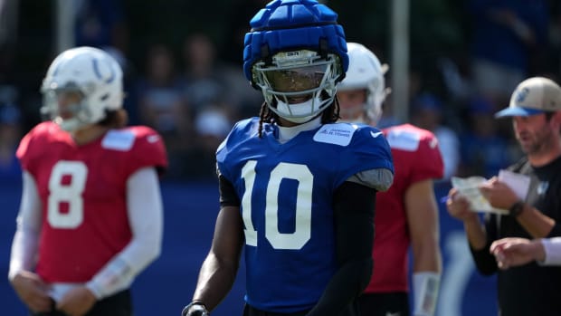 Colts receiver Adonai Mitchell (blue jersey and helmet) rests between plays during training camp practice. 