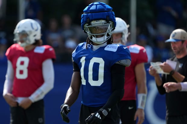 Football player Adonai Mitchell lines up for a play in practice while wearing a blue jersey.