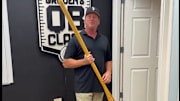 Jon Gruden unboxing a package of merchandise from the Gophers football program