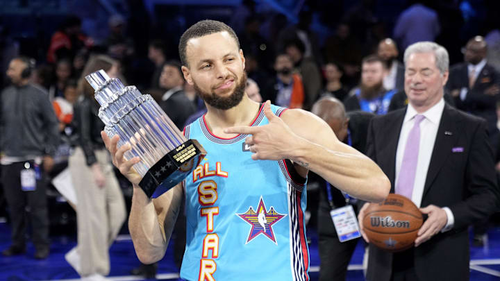 Stephen Curry of the Golden State Warriors celebrates with the MVP trophy after the NBA All-Star Game.
