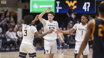 Dec 3, 2025; Morgantown, West Virginia, USA; West Virginia Mountaineers guard Honor Huff (3) celebrates with West Virginia Mountaineers guard Treysen Eaglestaff (52) and West Virginia Mountaineers guard Jasper Floyd (1) during the second half against the Coppin State Eagles at Hope Coliseum. Mandatory Credit: Ben Queen-Imagn Images