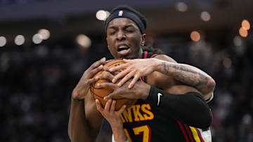 Atlanta Hawks center Onyeka Okongwu and Milwaukee Bucks guard Ryan Rollins battle for control of the ball