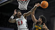 Feb 25, 2025; Cincinnati, Ohio, USA;  Cincinnati Bearcats forward Dillon Mitchell (23) swats the ball away from Baylor Bears forward Norchad Omier (15) in the second half at Fifth Third Arena. Mandatory Credit: Aaron Doster-Imagn Images