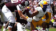 Sep 7, 2024; College Station, Texas, USA; Texas A&M Aggies offensive lineman Trey Zuhn III (60) helps up running back Amari Daniels (5) during the first quarter at Kyle Field. Mandatory Credit: Dustin Safranek-Imagn Images