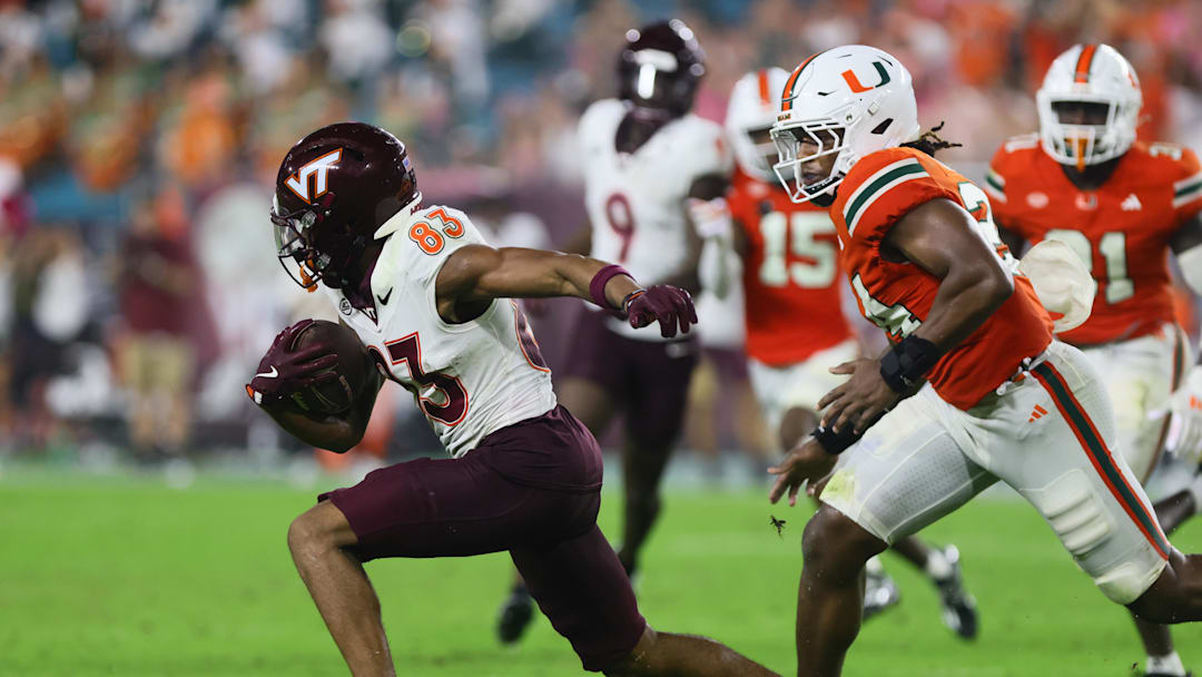 Sep 27, 2024; Miami Gardens, Florida, USA; Virginia Tech Hokies wide receiver Jaylin Lane (83) runs with the football past Miami Hurricanes linebacker Malik Bryant (24) during the fourth quarter at Hard Rock Stadium. Mandatory Credit: Sam Navarro-Imagn Images