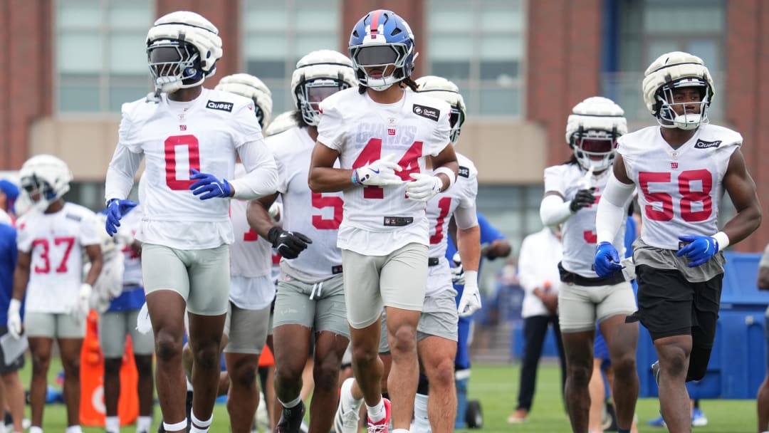 Jul 25, 2024; East Rutherford, NY, USA; New York Giants linebacker Brian Burns (0), cornerback Nick McCloud (44) and inside linebacker Bobby Okereke (58) take the field during training camp at Quest Diagnostics Training Center.  