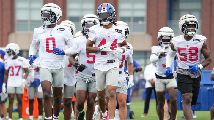 Jul 25, 2024; East Rutherford, NY, USA; New York Giants linebacker Brian Burns (0), cornerback Nick McCloud (44) and inside linebacker Bobby Okereke (58) take the field during training camp at Quest Diagnostics Training Center.  