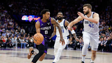 Mar 26, 2024; Sacramento, California, USA; Sacramento Kings guard Malik Monk (0) dribbles the ball past Dallas Mavericks guard Kyrie Irving (11) during the third quarter at Golden 1 Center. Mandatory Credit: Sergio Estrada-Imagn Images