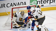May 12, 2025; Edmonton, Alberta, CAN; Vegas Golden Knights goalie Adin Hill (33) and defenseman Nicolas Hague (14)  battles for the puck with Edmonton Oilers left winger Zach Hyman (18) during the second period in game three of the second round of the 2025 Stanley Cup Playoffs at Rogers Place. Mandatory Credit: Walter Tychnowicz-Imagn Images