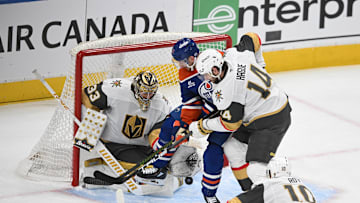 May 12, 2025; Edmonton, Alberta, CAN; Vegas Golden Knights goalie Adin Hill (33) and defenseman Nicolas Hague (14)  battles for the puck with Edmonton Oilers left winger Zach Hyman (18) during the second period in game three of the second round of the 2025 Stanley Cup Playoffs at Rogers Place. Mandatory Credit: Walter Tychnowicz-Imagn Images