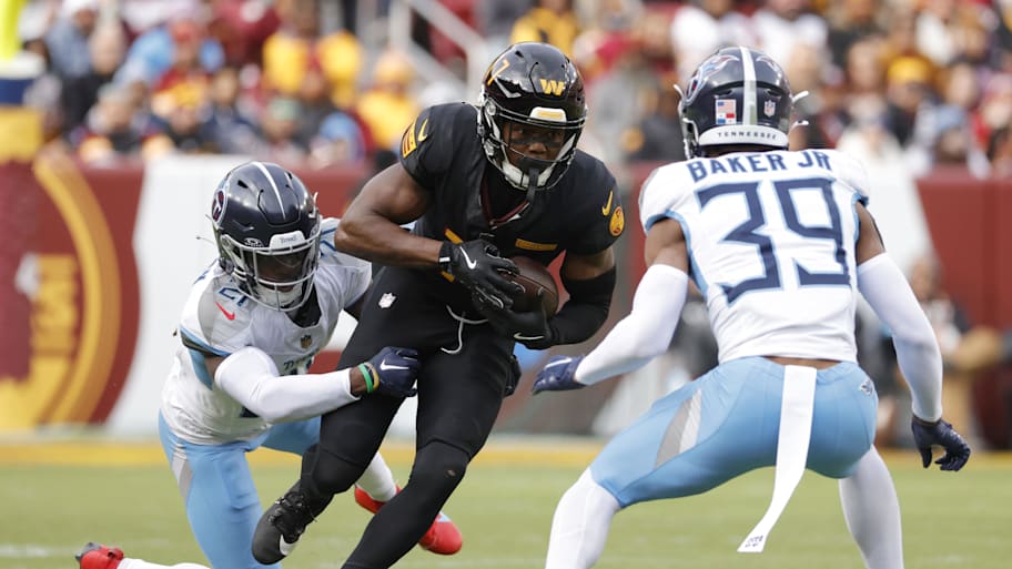 Washington Commanders wide receiver Terry McLaurin carries the ball as Tennessee Titans cornerback Roger McCreary. | Amber Searls-Imagn Images