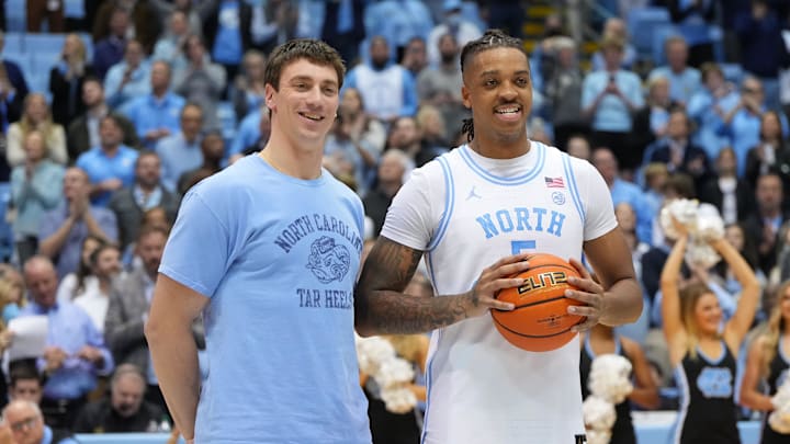 Jan 21, 2023; Chapel Hill, North Carolina, USA; Former North Carolina Tar Heels great Tyler Hansbrough presents forward Armando Bacot (5) with the game ball after the game. Bacot became the all-time Tar Heels rebounding leader during the game breaking Hansbrough   s record. Mandatory Credit: Bob Donnan-Imagn Images