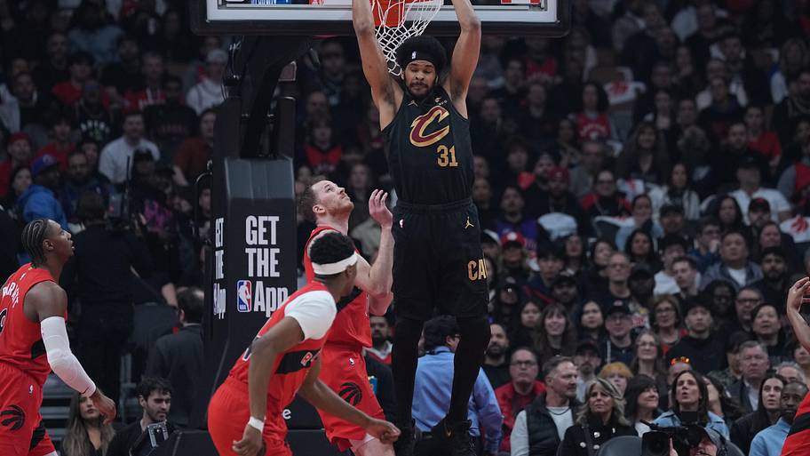 Cleveland Cavaliers center Jarrett Allen scores a basket over Toronto Raptors center Jakob Poeltl.