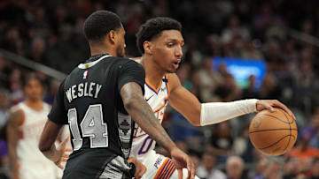 Apr 11, 2025; Phoenix, Arizona, USA; Phoenix Suns forward Ryan Dunn (0) dribbles against San Antonio Spurs guard Blake Wesley (14) during the second half at Footprint Center. Mandatory Credit: Joe Camporeale-Imagn Images