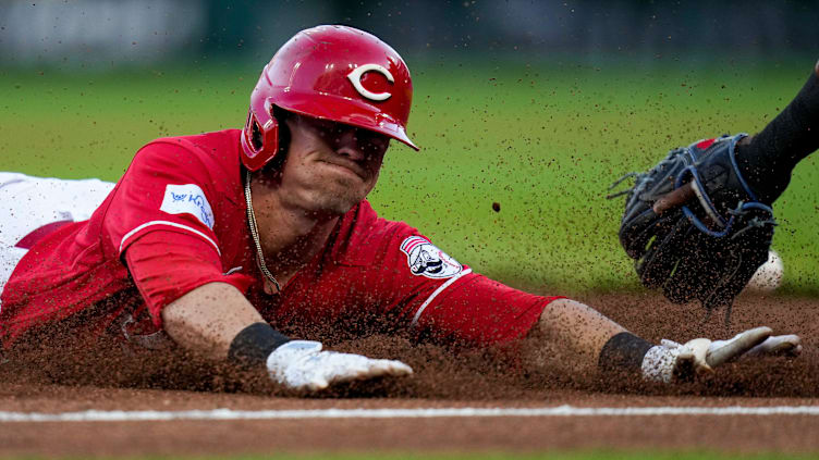 Cincinnati Reds center fielder TJ Friedl (29) dives into third base.