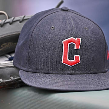Jun 27, 2024; Kansas City, Missouri, USA; A general view a Cleveland Guardians hat and glove on the dugout railing  before a game against the Kansas City Royals at Kauffman Stadium. Mandatory Credit: Peter Aiken-Imagn Images