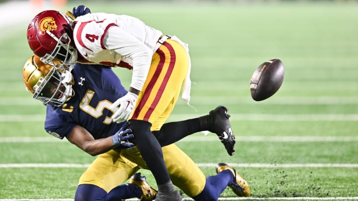 Oct 14, 2023; South Bend, Indiana, USA; USC Trojans wide receiver Mario Williams (4) loses the ball as he is hit by Notre Dame Fighting Irish cornerback Cam Hart (5) in the fourth quarter at Notre Dame Stadium. Notre Dame won 48-20. 