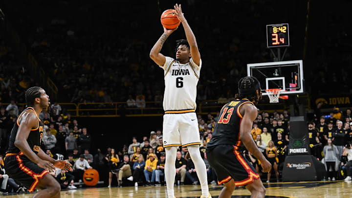 Jan 28, 2026; Iowa City, Iowa, USA; Iowa Hawkeyes guard Tavion Banks (6) shoots the ball as Southern California Trojans forward Ezra Ausar (2) and guard Kam Woods (13) defend during the second half at Carver-Hawkeye Arena. Mandatory Credit: Jeffrey Becker-Imagn Images