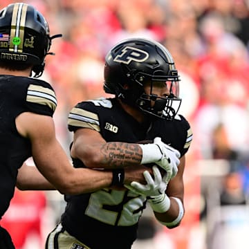 Purdue Boilermakers quarterback Ryan Browne (15) hands the ball off to running back Antonio Harris (22) 