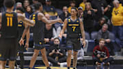 Feb 8, 2025; Morgantown, West Virginia, USA; West Virginia Mountaineers guard Javon Small (7) celebrates with West Virginia Mountaineers guard Toby Okani (5) following a score during the second half against the Utah Utes at WVU Coliseum. Mandatory Credit: Ben Queen-Imagn Images
