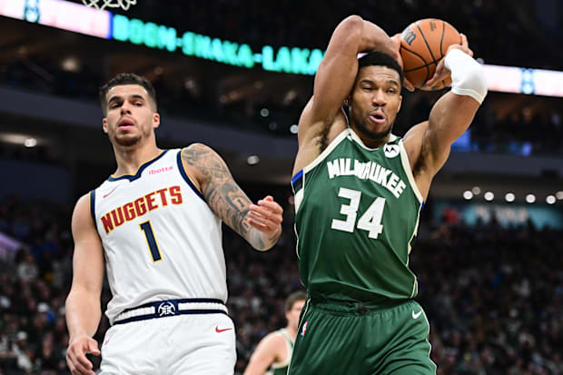 Milwaukee Bucks forward Giannis Antetokounmpo (34) grabs a rebound against Denver Nuggets forward Michael Porter Jr. (1)