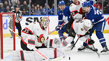 Mar 15, 2025; Toronto, Ontario, CAN;  Ottawa Senators goalie Linus Ullmark (35) makes a save as defensemen Artem Zub (2) and Thomas Chabot (72) hold back Toronto Maple Leafs forward Auston Matthews (34) in the third period at Scotiabank Arena. Mandatory Credit: Dan Hamilton-Imagn Images
