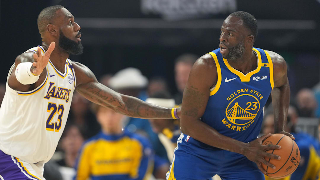 Dec 25, 2024; San Francisco, California, USA; Golden State Warriors forward Draymond Green (right) handles the ball against Los Angeles Lakers forward LeBron James (left) during the first quarter at Chase Center. Mandatory Credit: Darren Yamashita-Imagn Images