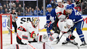 Mar 15, 2025; Toronto, Ontario, CAN;  Ottawa Senators goalie Linus Ullmark (35) makes a save as defensemen Artem Zub (2) and Thomas Chabot (72) hold back Toronto Maple Leafs forward Auston Matthews (34) in the third period at Scotiabank Arena. Mandatory Credit: Dan Hamilton-Imagn Images