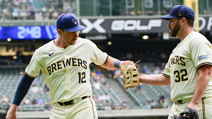 Aug 29, 2024; Milwaukee, Wisconsin, USA; Milwaukee Brewers first baseman Rhys Hoskins (12) is greeted by  starting pitcher Aaron Civale (32) after making a play to rob San Francisco Giants designated hitter Michael Conforto (not pictured) of a hit in the sixth inning at American Family Field. Mandatory Credit: Benny Sieu-Imagn Images