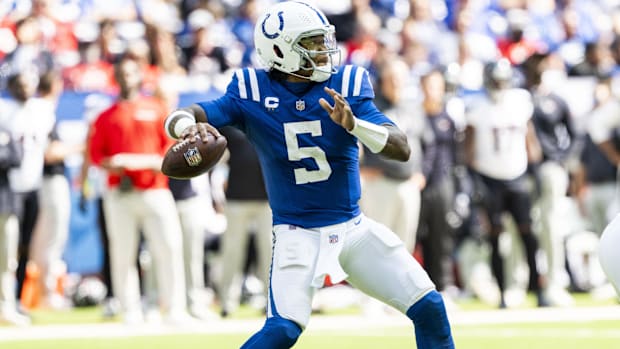 Colts QB Anthony Richardson (blue jersey; white pants) looks down field to throw a pass. 