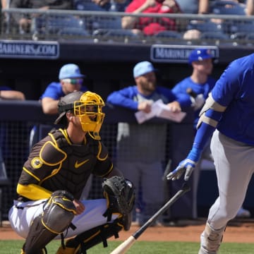 Mar 4, 2024; Peoria, Arizona, USA; Chicago Cubs first baseman Dominic Smith (12) hits a double against the San Diego Padres in the first inning at Peoria Sports Complex.