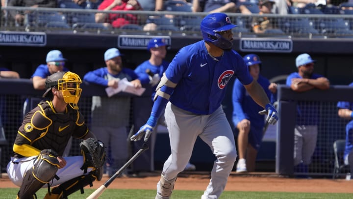 Mar 4, 2024; Peoria, Arizona, USA; Chicago Cubs first baseman Dominic Smith (12) hits a double against the San Diego Padres in the first inning at Peoria Sports Complex.