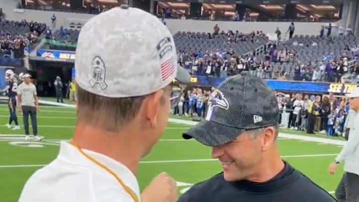 Los Angeles Chargers coach Jim Harbaugh (left) interacts with his brother and Baltimore Ravens coach John Harbaugh before the two teams' game at SoFi Stadium on November 26, 2024. 