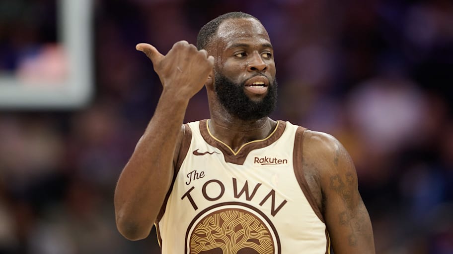 Golden State Warriors forward Draymond Green gestures toward the Sacramento Kings bench.