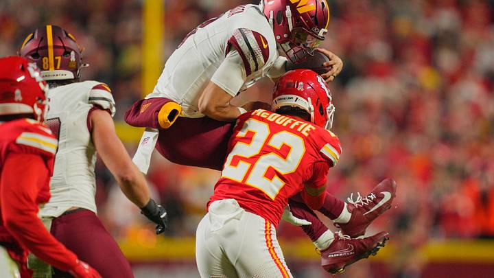 Oct 27, 2025; Kansas City, Missouri, USA; Kansas City Chiefs cornerback Trent McDuffie (22) tackles Washington Commanders quarterback Marcus Mariota (8) during the second quarter of the game at GEHA Field at Arrowhead Stadium. Mandatory Credit: Jay Biggerstaff-Imagn Images
