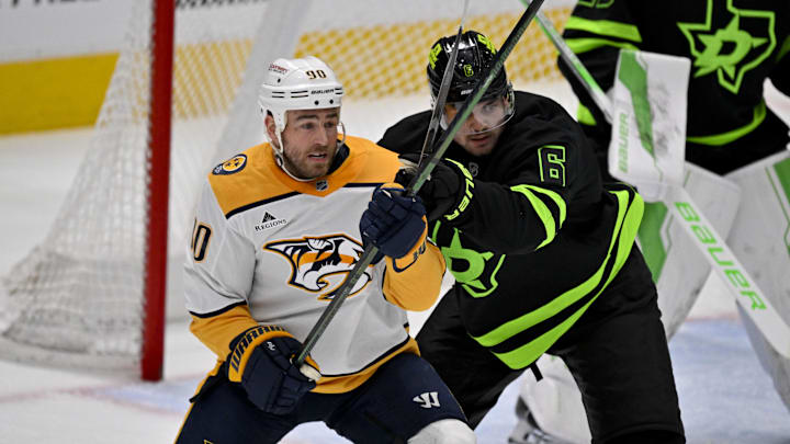 Apr 3, 2025; Dallas, Texas, USA; Nashville Predators center Ryan O'Reilly (90) and Dallas Stars defenseman Lian Bichsel (6) battle for position in the Dallas zone during the second period at the American Airlines Center. Mandatory Credit: Jerome Miron-Imagn Images