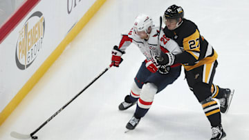 Apr 17, 2025; Pittsburgh, Pennsylvania, USA;  Washington Capitals center Lars Eller (20) over the puck against Pittsburgh Penguins defenseman Ryan Graves (27) during the third period at PPG Paints Arena. Mandatory Credit: Charles LeClaire-Imagn Images