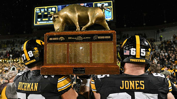 Nov 2, 2024; Iowa City, Iowa, USA; Iowa Hawkeyes offensive lineman Logan Jones (65) and offensive lineman Mason Richman (78) carry the Heartland trophy after the game against the Wisconsin Badgers at Kinnick Stadium. Mandatory Credit: Jeffrey Becker-Imagn Images