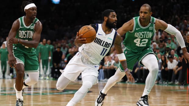 Irving drives to the basket against Celtics guard Jrue Holiday and center Al Horford during Game 5 of the 2024 NBA Finals.