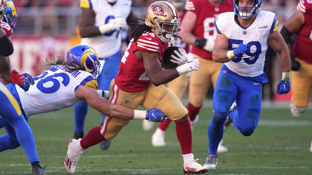 Jan 7, 2024; Santa Clara, California, USA; San Francisco 49ers running back Jordan Mason (24) carries the ball against Los Angeles Rams linebackers Christian Rozeboom (left) and Troy Reeder (59) during the second quarter at Levi's Stadium. Mandatory Credit: Darren Yamashita-USA TODAY Sports