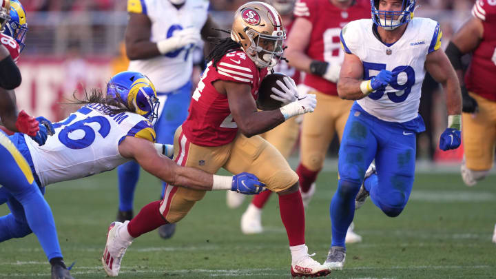 Jan 7, 2024; Santa Clara, California, USA; San Francisco 49ers running back Jordan Mason (24) carries the ball against Los Angeles Rams linebackers Christian Rozeboom (left) and Troy Reeder (59) during the second quarter at Levi's Stadium. Mandatory Credit: Darren Yamashita-USA TODAY Sports