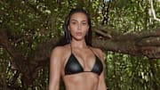 Kim Kardashian was photographed by Greg Swales in the Dominican Republic. Swimsuit by SKIMS. Pants by Balenciaga. 
