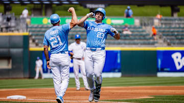 May 23, 2024; Charlotte, NC, USA; North Carolina Tar Heels designated hitter Alberto Osuna (23) celebrates a home run with head coach Scott Forbes in the first inning against the Pittsburgh Panthers during the ACC Baseball Tournament at Truist Field. Mandatory Credit: Scott Kinser-Imagn Images
