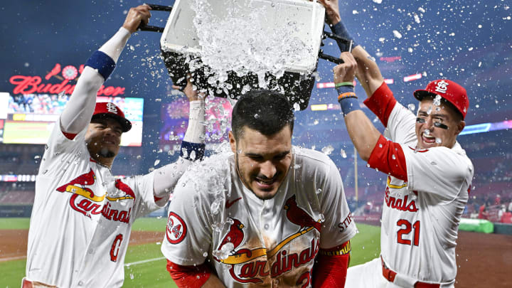 Aug 21, 2024; St. Louis, Missouri, USA;  St. Louis Cardinals third baseman Nolan Arenado (28) is doused with water by shortstop Masyn Winn (0) and center fielder Lars Nootbaar (21) after hitting a walk-off grand slam against the Milwaukee Brewers during the tenth inning at Busch Stadium.