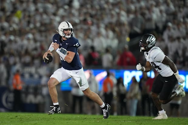 Penn State quarterback Drew Allar runs out of the pocket as Oregon linebacker Jerry Mixon chases.
