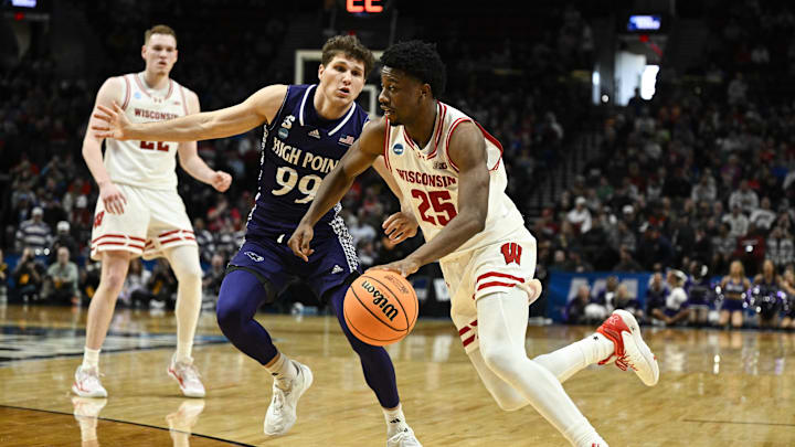 Mar 19, 2026; Portland, OR, USA; Wisconsin Badgers guard John Blackwell (25) drives against High Point Panthers guard Chase Johnston (99) during the second half of a first round game of the men's 2026 NCAA Tournament at Moda Center. Mandatory Credit: Troy Wayrynen-Imagn Images