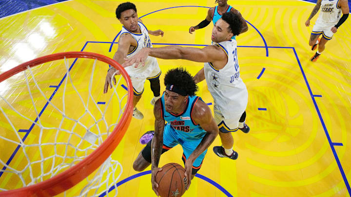 February 14, 2025; San Francisco, California, USA; Team G-League guard Dink Pate (1) of the Mexico City Capitanes drives to the basket against Team C forward Ryan Dunn (0) of the Phoenix Suns and forward Trayce Jackson-Davis (32) of the Golden State Warriors during the 2025 NBA Rising Stars Game at Chase Center. Mandatory Credit: Kyle Terada-Imagn Images