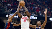 Nov 19, 2025; Cleveland, Ohio, USA; Houston Rockets center Clint Capela (30) looks to pass while being pressured by Cleveland Cavaliers centers Thomas Bryant (3) and Evan Mobley (4) during the first half at Rocket Arena. Mandatory Credit: David Dermer-Imagn Images