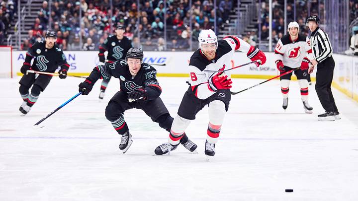 New Jersey Devils defenseman Johnathan Kovacevic (8) and Seattle Kraken center Berkly Catton (27) chase the puck: Blake Dahlin-Imagn Images